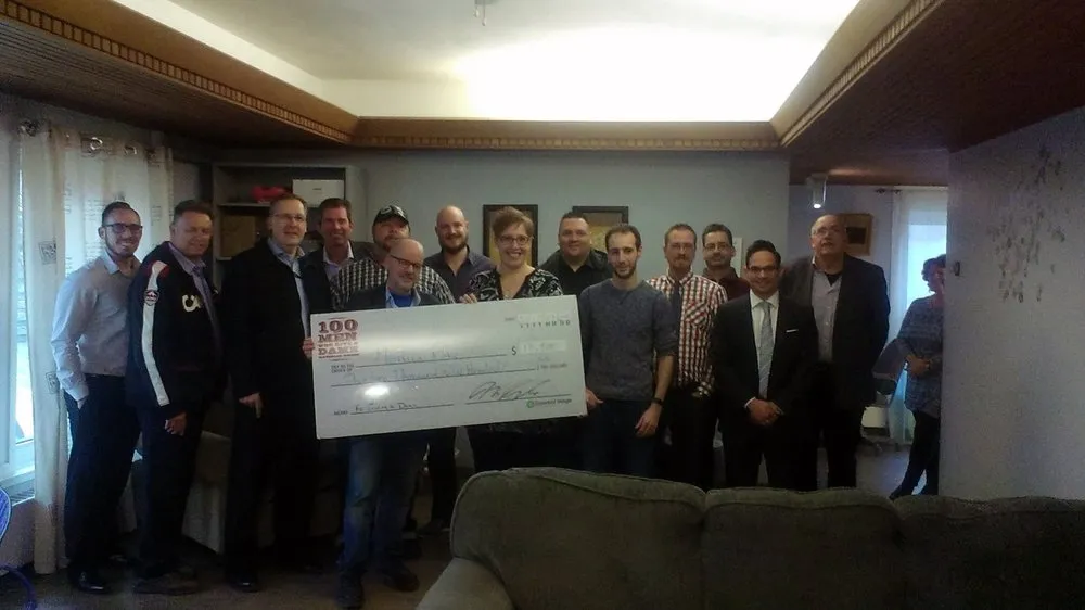 Men receiving a large check for charity