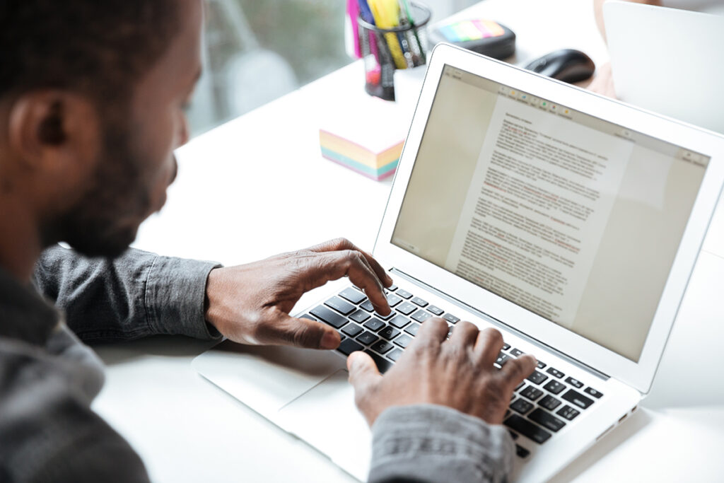 an image of a man typing content on a Macbook Air using seo best practices