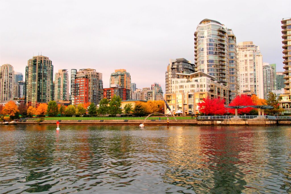 Vancouver skyline with modern high-rise buildings along the waterfront, featuring vibrant autumn trees, reflecting the beauty of urban life in a search engine optimization Victoria BC context.