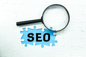 A magnifying glass positioned over a puzzle with the missing piece labeled "SEO," emphasizing the strategic role of white label SEO marketing in completing a brand’s online presence.