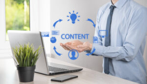 A business professional holding out their hands in front of a laptop, surrounded by blue graphics symbolizing the content in marketing cycle, including ideas, documents, and analysis.
