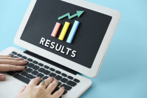 A laptop with colorful bar graphs and the word "RESULTS" displayed on the screen, symbolizing growth and success. This illustrates achieving better site rankings through consistent improvement and analytics.