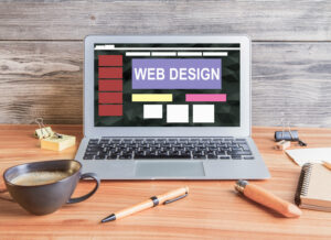 A sleek laptop on a wooden desk displaying a web design interface, symbolizing modern SEO website design and development.