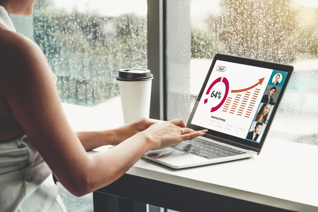 A professional analyzing marketing data on a laptop during a virtual meeting, highlighting the importance of PPC services in boosting online sales.