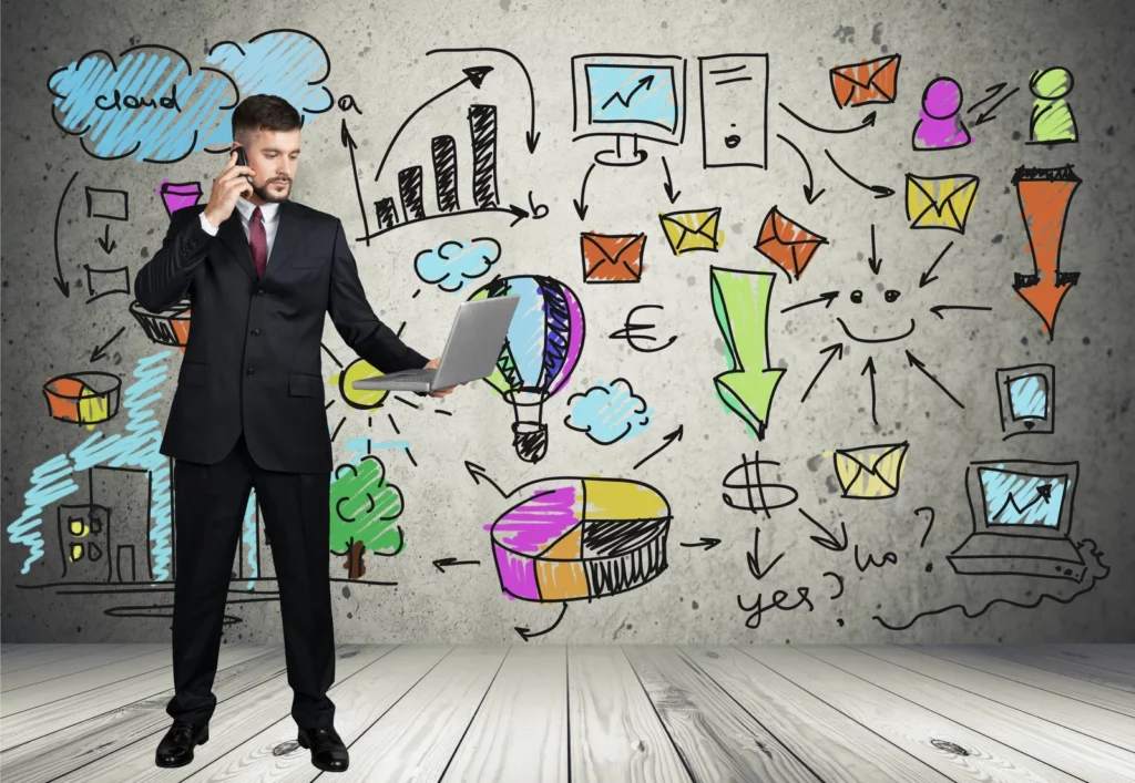 A businessman in a suit holding a laptop and talking on the phone, standing against a background filled with colorful hand-drawn marketing concepts, including financial growth, networking, and customer engagement. This creative setup showcases different kinds of marketing strategies used in modern business development.