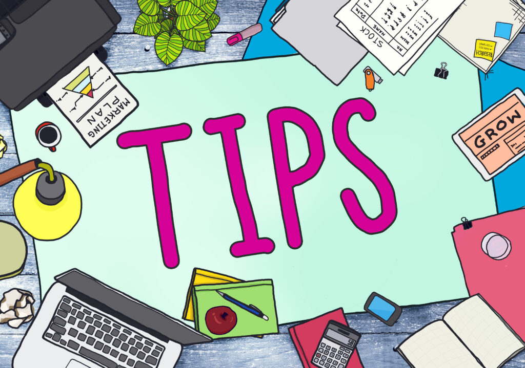 Illustration of a workspace with the word "TIPS" in large pink letters at the center, surrounded by various office items including a laptop, calculator, smartphone, coffee cup, desk lamp, documents labeled "MARKETING PLAN" and "GROW," folders, a notepad, a pen, an apple, and leafy green plants.