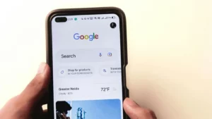 A person holding a smartphone displaying the Google search homepage, representing mobile use of the Google Ads ad preview tool for checking ad placements and visibility.
