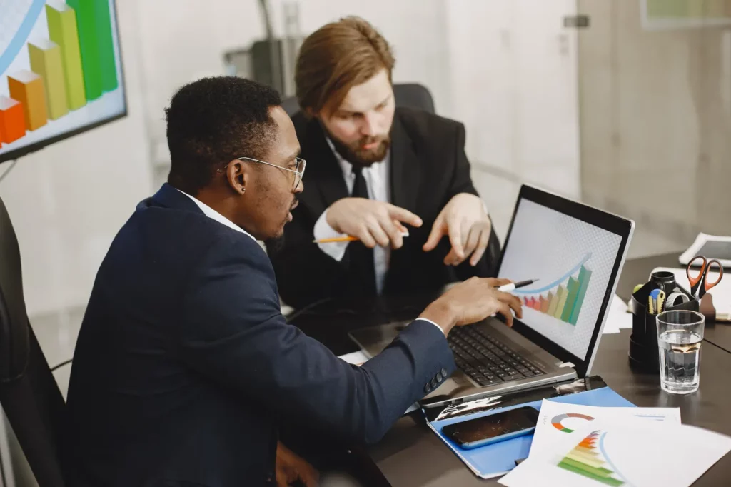 Google ads automated bidding being used by two business professionals reviewing data 