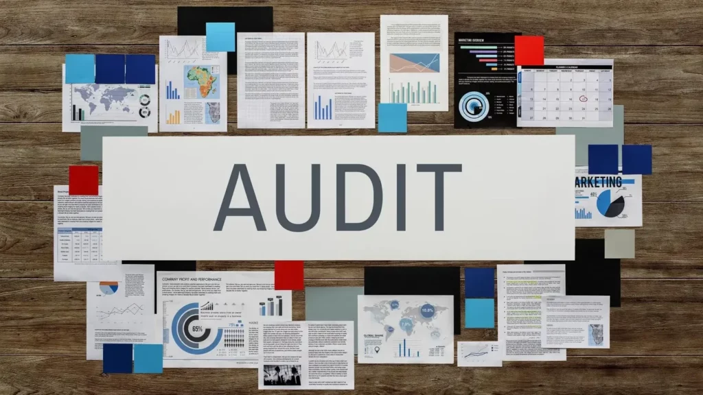 Google ads policy compliance being checked via an audit on a table surrounded by paperwork