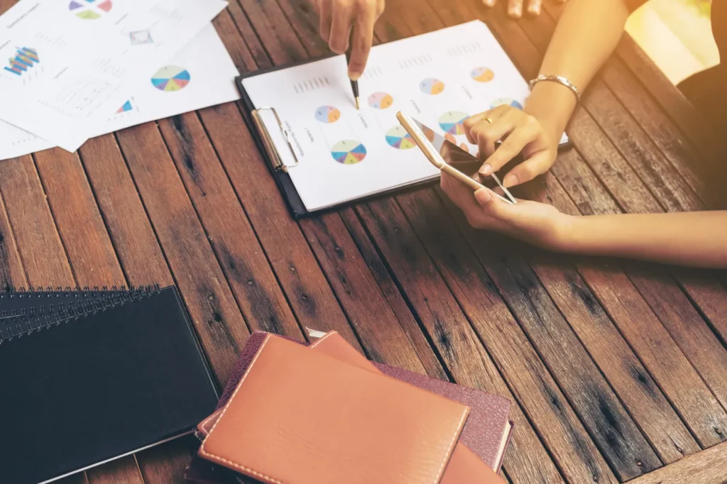 business-group-meeting-freelance-working-group google ads performance insights being evaluated by a business woman holding a smart phone at a desk