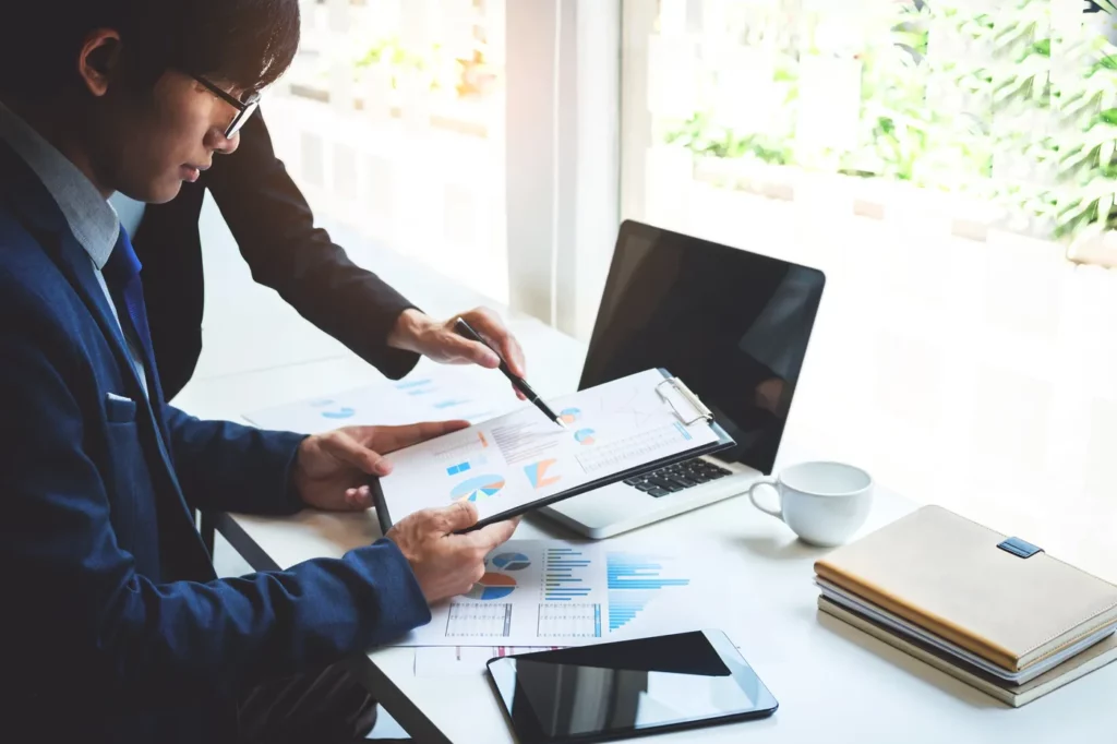 Google ads bidding strategies being taught to an office professional by a coworker