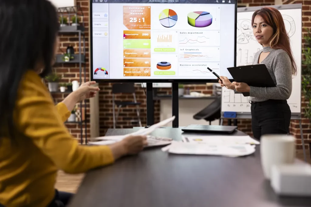 Google ads campaign budget constraints being reviewed by two business women using charts to go over data together 