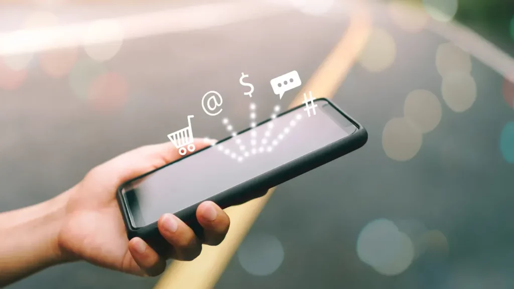 google ads for mobile apps represented by a smart phone in someones hand with 4 icons bouncing off 