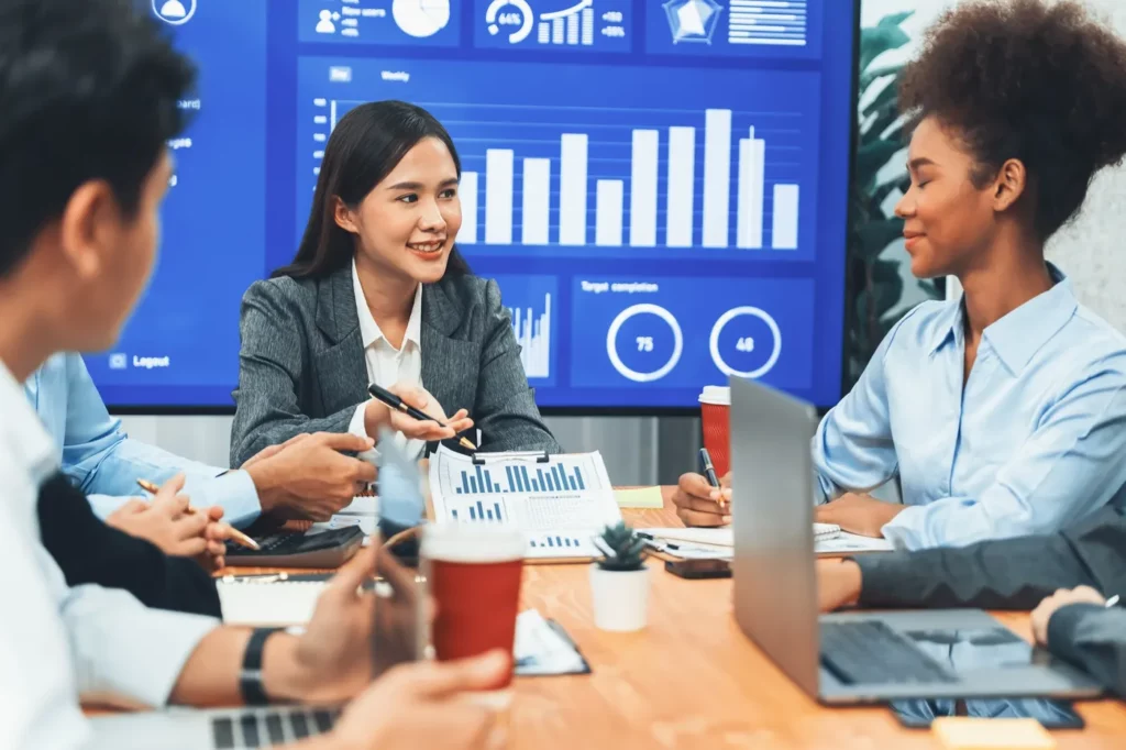 young-asian-businesswoman-presenting-data-analysis-dashboard-tv-concord Google ads automated bid strategies results being analyzed by business team