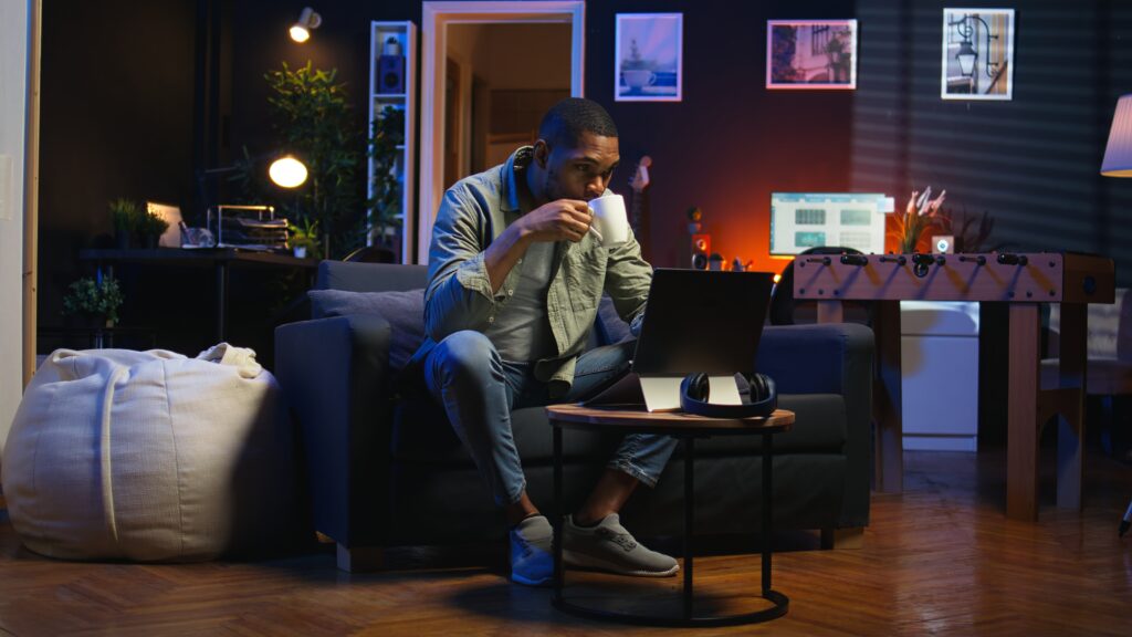 working remotely on laptop at home office setup enjoying a coffee, a professional researches the Best hosting for small business 